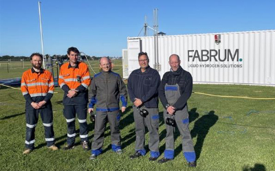 Team von fünf Fachleuten vor einem FABRUM Container für flüssige Wasserstofflösungen im Freien.