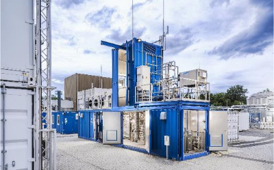 Modulare Industrieanlage mit blauen Containern und technischen Apparaturen im Freien.