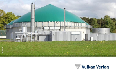 Biogasanlage mit grünem Gärdom und technischen Anlagen auf einer Grünfläche.